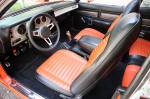 There&rsquo;s a lot happening with the interior that only Mopar geeks will notice at first glance. The upholstery was provided by Legendary Interiors and is called the Halloween style due to the black and orange coloration, which was actually a 1971 option. The stir stick coming through the floor is attached to a Keisler five-speed OD trans. Fifth gear carries a .068 ratio for cruising. The dash is another interesting nod to history. John Herlitz, one of the Chrysler designers for the 1971 model year, was inspired by airplanes and frankly, hated the wood grain appliqu&eacute; on the Plymouth dashboard. His suggested change was this Astrotone treatment  that looks bitchin&rsquo;.  &raquo; Click to zoom ->